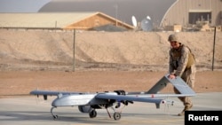 U.S. Marine pushes RQ-7B Shadow UAV drone following its landing at Camp Leatherneck, Afghanistan, Nov. 10, 2011.