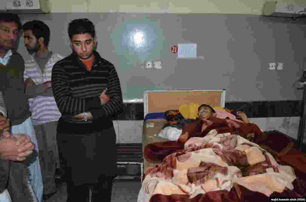 زیر علاج زخمی طالب علم کے رشتے دار اس کی عیادت کر رہے ہیں۔