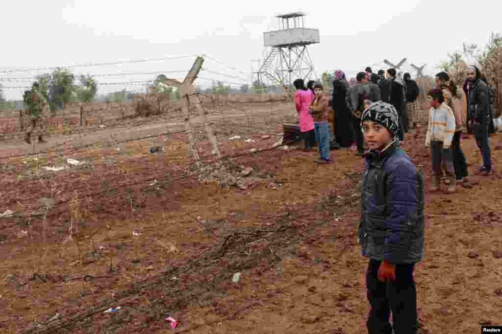 Para pengungsi Suriah menunggu untuk masuk ke Turki di perbatasan Suriah-Turki di desa Shamm Alqrain, 13 Januari 2014. 