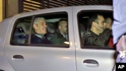 Portugal's former Prime Minister Jose Socrates, in the back seat of the car on the left, leaves a court in a Portuguese police car after being questioned, in Lisbon, Sunday, Nov. 23, 2014.