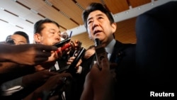 ນາຍົກລັດຖະມົນຕີຍີ່ປຸ່ນ ທ່ານ Shinzo (ກາງ) Abe ກ່າວຕໍ່ສື່ມວນຊົນ ລຸນຫລັງທີ່ເຂົ້າຮ່ວມ ກອງປະຊຸມ ສະພາຄວາມໝັ້ນຄົງ ຂອງຍີ່ປຸ່ນ ທີ່ທໍານຽບນາຍົກ ຢູ່ກຸງໂຕກຽວ ໃນວັນທີ12 ກຸມພາ 2013, ກ່ຽວກັບການທົດລອງນີວເຄລຍ ຂອງເກົາຫລີເໜືອ.
REUTERS/Issei Kato 