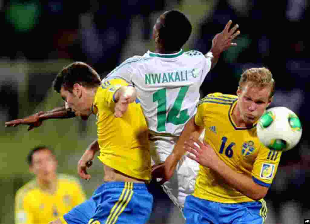 Chidiebere Nwakali of Nigeria is sandwiched by Sweden defenders during a semifinal match of the World Cup U-17 in Dubai.