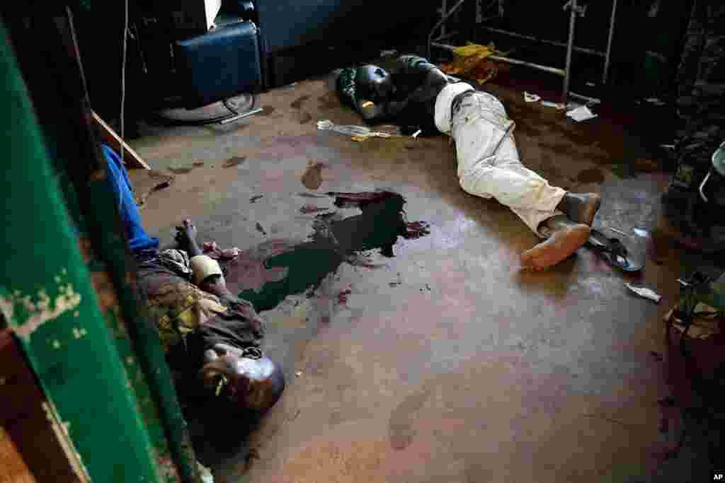 A young man screams in pain as he lies in a pool of blood on the floor of Bangui's hospital, Bangui, Central African Republic, Dec. 5, 2013.