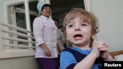 Adoption candidate Mark, 2, reacts in the children's department of a local hospital in Russia's Siberian city of Krasnoyarsk, March 23, 2011.