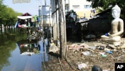 A Buddha's statue sits amidst trash at a half-flooded street corner in Ayutthaya province, central Thailand November 8, 2011.