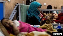 FILE: A mother holds her one-year-old baby, at the malnutrition ward for infants of Indira Gandhi Children's hospital in Kabul, Afghanistan, Oct. 23, 2021.