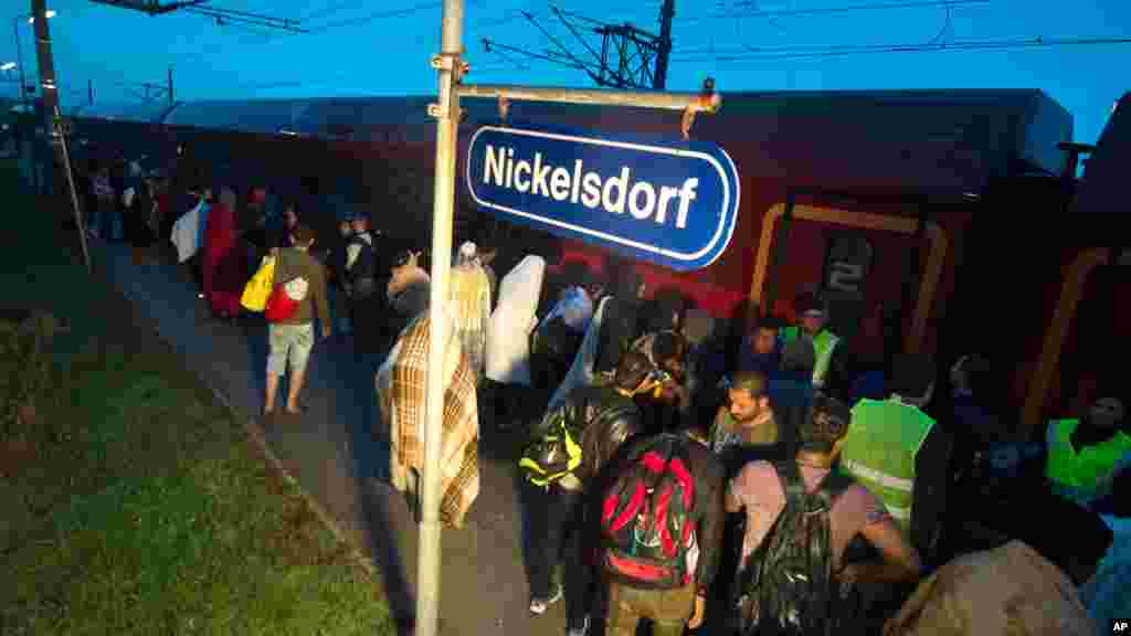 Des migrants montent dans le train après leur arrivée&nbsp;au poste&nbsp;frontalier entre Hegyeshalom, à Hongrie, et Nickelsdorf, em Autriche, samedi 5 septembre 2015