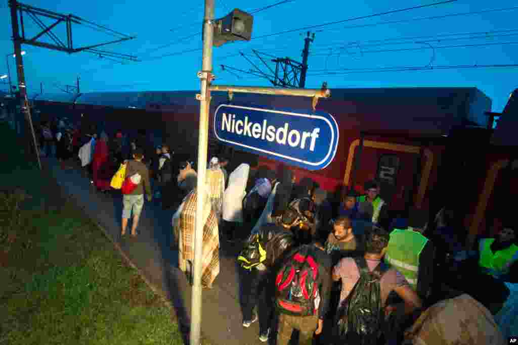 Migrants board a train after arriving at the border station between Hegyeshalom, Hungary, and Nickelsdorf, Austria, Saturday morning Sept. 5, 2015.