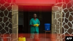 An attendant charged to handle the access to the Ebola security zone stands at the entrance of the Wangata Reference Hospital in Mbandaka, Democratic Republic of the Congo, May 20, 2018.