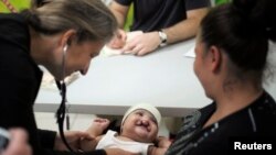 FILE - A doctor examines a cleft-lipped baby during a medical evaluation provided by Operation Smile volunteers at San Felipe hospital in Tegucigalpa November 14, 2012.