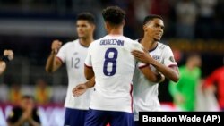 Des joueurs américains célèbrent la victoire 1-0 de leur équipe contre la Jamaïque lors d'un match de football de quart de finale de la Gold Cup de la CONCACAF, dimanche 25 juillet 2021, à Arlington, au Texas.