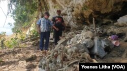 Tadanugi dan Kanca Awusi memperlihatkan tulang belulang dan tengkorak di situs kubur prasejarah Toyali yang terdampak pembukaan jalan PT Poso Energy, Minggu, 14 Februari 2021. (Foto: Yoanes Litha)