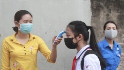 A student is scanned for temperature before entering Dinh Cong secondary school in Hanoi, Vietnam Monday, May 4, 2020.