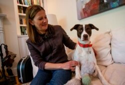 Jessica Wright sits next to her dog Penny at her home, Apr. 6, 2021, in Decatur, Ga. Wright had to navigate distanced veterinarian appointments as she took Penny into her home during the coronavirus pandemic.