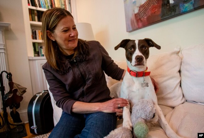 Jessica Wright sits next to her dog Penny at her home, Apr. 6, 2021, in Decatur, Ga. Wright had to navigate distanced veterinarian appointments as she took Penny into her home during the coronavirus pandemic.