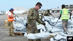 Members of the US army help load supplies at Beira International airport, Mozambique, Monday, April 1, 2019, joining the humanitarian aid efforts following a cyclone that hit the country on March 14. 