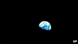 ARCHIVO- Una pequeña bola azul y blanca llamada Tierra aparece por vez primera en esta gráfica del astronauta William Anders durante la misión Apolo 8. Nochebuena de 1968. (William Anders/NASA via AP).