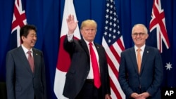 Prezidan ameriken Donald trump nan mitan ak Premye minis japonè a, Shinzo Abe, agoch, e premye minis Ostrali a Malcolm Turbull, adwat pandan somè ASEAN nan Filipin, lendi 13 novanm 2017 la. 