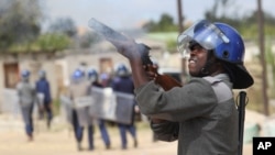 Armed Zimbabwean police battle rioters in Harare, July, 4, 2016. The violence came amid a surge in protests in recent weeks because of economic hardships and alleged mismanagement by the government of President Robert Mugabe.