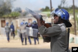 Armed Zimbabwean police battle rioters in Harare, July, 4, 2016. The violence came amid a surge in protests in recent weeks because of economic hardships and alleged mismanagement by the government of President Robert Mugabe.