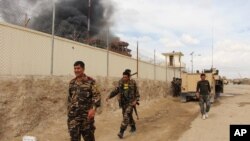 FILE - Smoke rises from a building where Taliban insurgents hid during a fight with Afghan security forces in Helmand province, Afghanistan, March 9, 2016. 