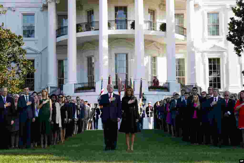 President Donald Trump and first lady Melania Trump stand as &quot;Taps&quot; is played to mark the anniversary of the Sept. 11 terrorist attacks, on the South Lawn of the White House in Washington.