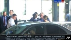 Image released by Russia24 TV channel, shows Russian lawyer Anatoly Kucherena, second right in the center, and National Security Agency leaker Edward Snowden, center back to a camera, Aug. 1, 2013.