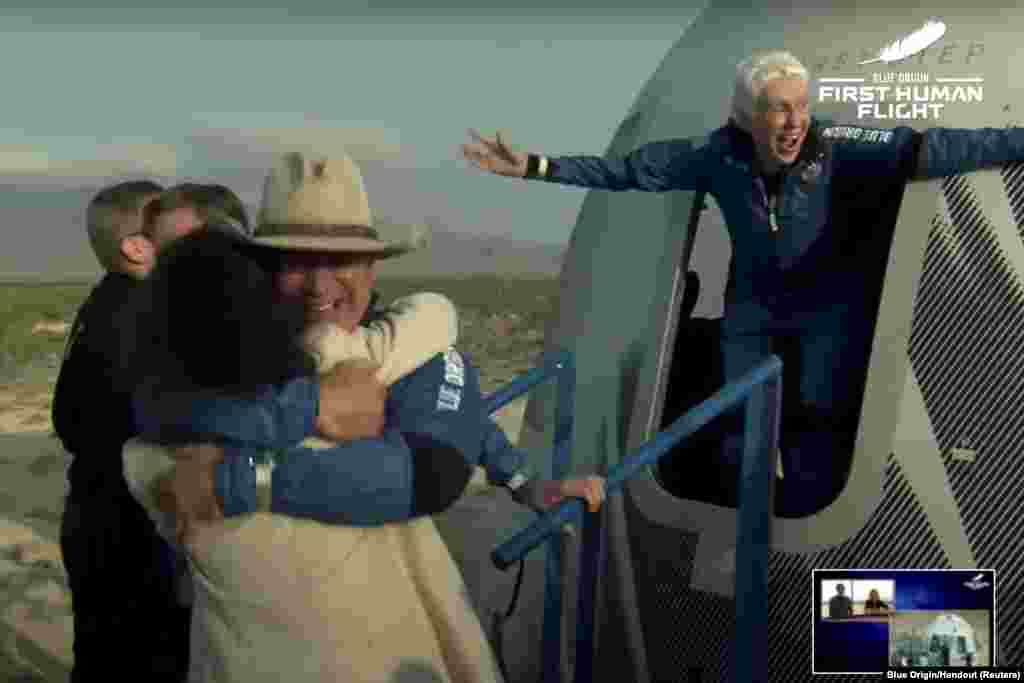 Billionaire Jeff Bezos and pioneering female aviator Wally Funk emerge from Blue Origin&#39;s New Shepard rocket after returning from the world&#39;s first unpiloted suborbital flight near Van Horn, Texas.
