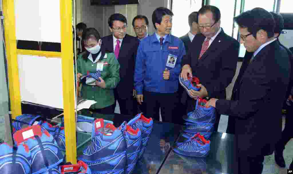 Ahn Hong-joon, chairman of the South Korean National Assembly's Foreign Affairs and Unification Committee, examines a shoe manufactured at a factory at the inter-Korean industrial park in Kaesong, North Korea, Oct. 30, 2013.