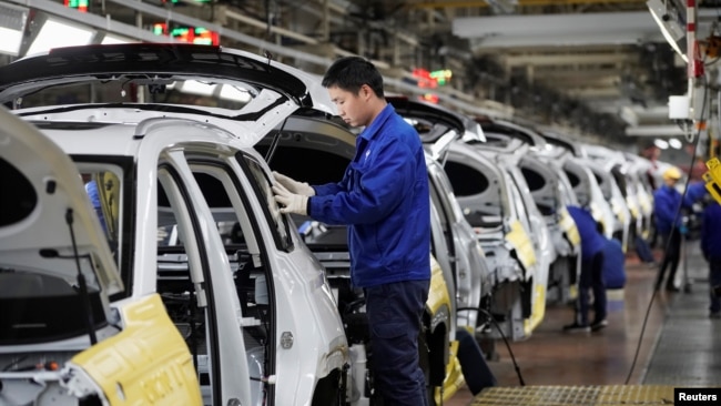 中国工人2019年2月28日在广西柳州通用汽车与中企合资的工厂生产线上工作。