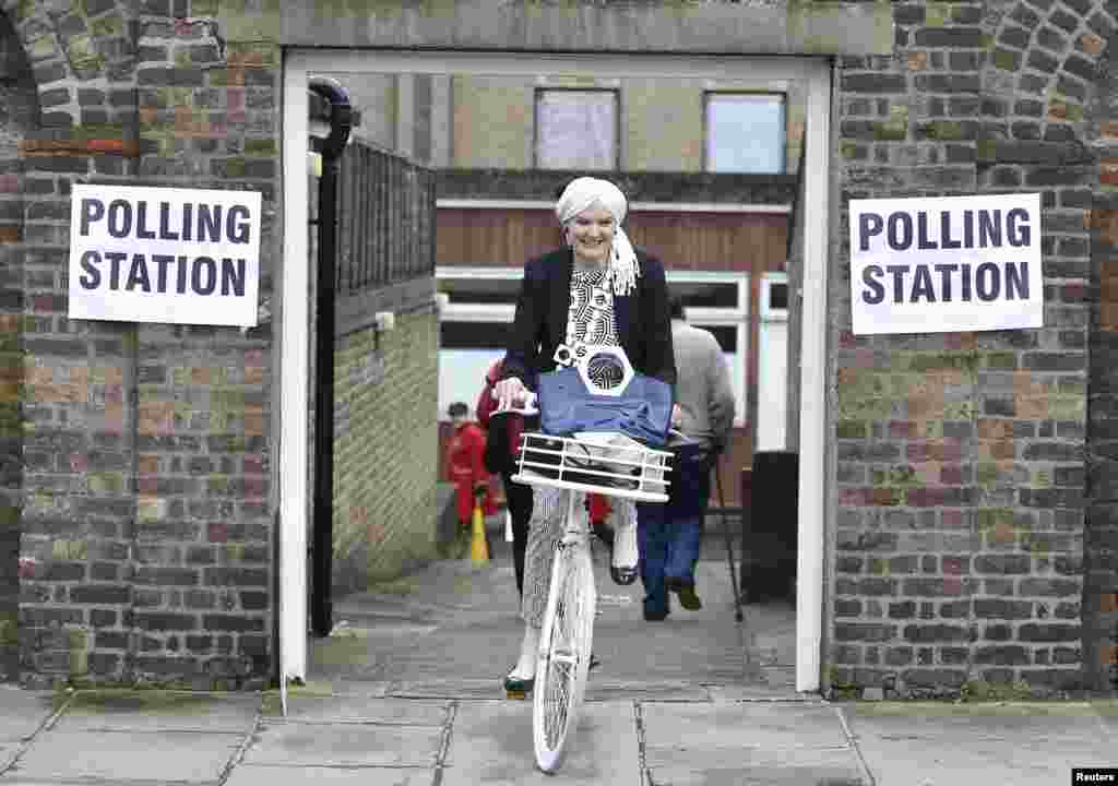 A woman cycles out of a polling station for the referendum on the European Union in the Chelsea neighborhood of London, Britain.