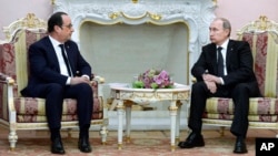 Russian President Vladimir Putin (R) listens to French President Francois Hollande during their meeting in Yerevan, Armenia, April 24, 2015.