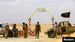 FILE - Rebels under Libyan rebel leader Ibrahim Jathran guard the entrance of the al-Ghani oil field.