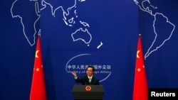 FILE - China's Foreign Ministry spokesman Hong Lei conducts a news conference in Beijing.