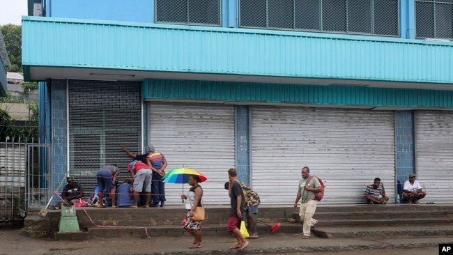 Locals gather outside closed shops in Honiara, Solomon Islands, Dec. 6, 2021.