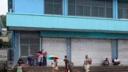 Locals gather outside closed shops in Honiara, Solomon Islands, Dec. 6, 2021.