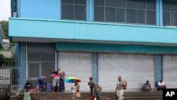 Locals gather outside closed shops in Honiara, Solomon Islands, Dec. 6, 2021.