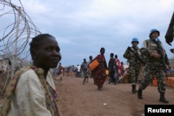 FILE - United Nations peacekeepers patrol in the camp for displaced people inside the United Nations Mission in South Sudan (UNMISS) compound in Malakal, Upper Nile State, March 4, 2014.