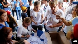 Volunteers count the ballots after the poll station closed during a symbolic referendum in Caracas, Venezuela, Sunday, July 16, 2017.