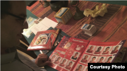 Philippe Sion, born in Switzerland, is looking at the Swiss page in his Panini trading book for this year's World Cup. (Rachel Dornhelm)