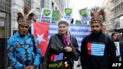Benny Wenda (kiri) bersama desainer Inggris, Vivienne Westwood (tengah) dan aktivis Papua Barat, Raki Ap (kanan) dalam aksi memprotes eksploitasi hutan hujan di Papua Barat, di luar kantor perusahaan energi BP, di London, 18 Oktober 2019. (Foto: AFP)