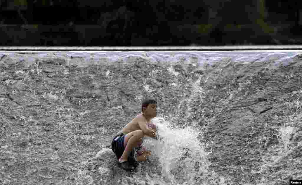 Một cậu bé làm mát trên một con đê ngăn sông Berounka khi nhiệt độ lên tới 37 độ C ở làng Zadní Treban gần thủ đô Praha, Cộng hòa Czech.