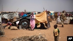 This photo taken March 9, 2014 and released by the United Nations African Union Mission in Darfur (UNAMID) shows a family at the Kalma refugee camp for internally displaced people, south of the Darfur town of Nyala, Sudan.