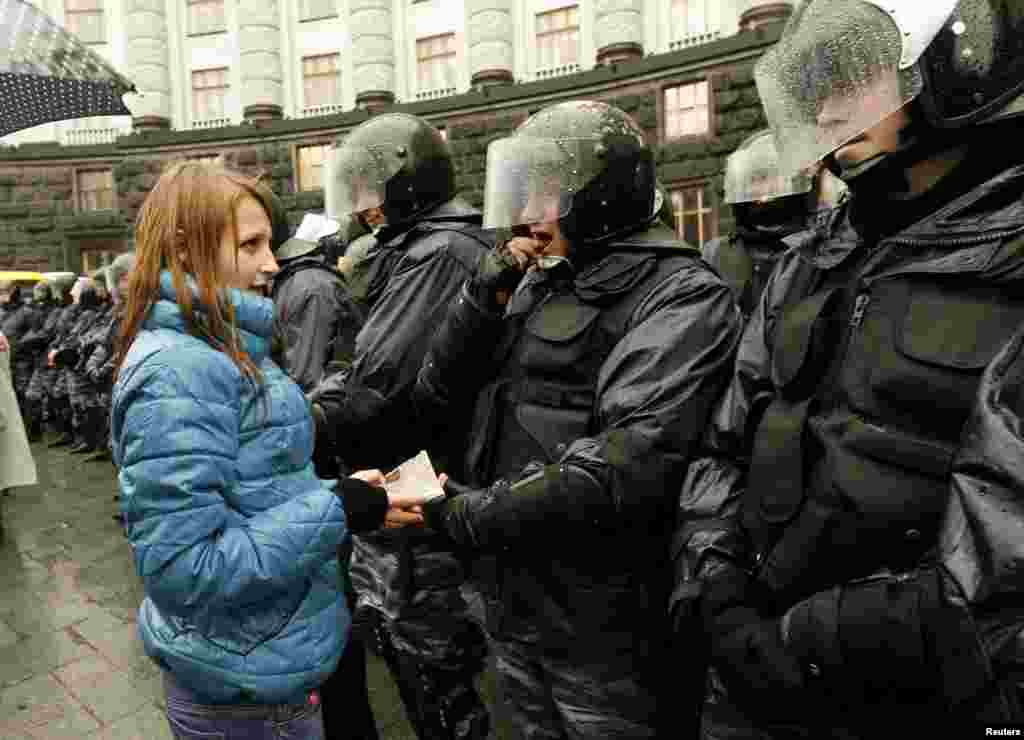 A woman gives riot police chocolate during a rally in support of EU integration in Kyiv, Nov. 25, 2013.