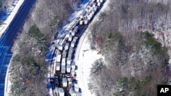 Drivers wait for the traffic to be cleared as cars and trucks are stranded on sections of Interstate 95, in Carmel Church, Va., Jan. 4, 2022. 