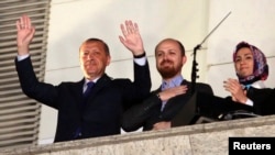 FILE - Turkish PM Tayyip Erdogan, accompanied by his son Bilal and daughter Sumeyye, greets his supporters at the AK Party headquarters in Ankara, March 30, 2014.