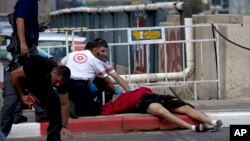 8일 이스라엘 텔아비브에서 의료진이 사망한 팔레스타인 시체를 점검하고 있다. 이 청년은 유대인 4명을 흉기로 찌른 후 이스라엘 경찰이 쏜 총에 맞아 사망했다.