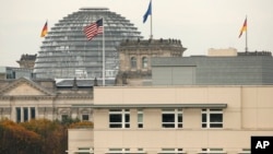 The U.S. flag flies on top of the U.S. embassy in front of the Reichstag building that houses the German Parliament, Bundestag, in Berlin, Germany, Oct. 25, 2013.