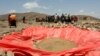 FILE - Displaced people gather at an artificial water pan near Habaas town of Awdal region, Somaliland, April 9, 2016. Across the Horn of Africa, millions have been hit by the severe El Nino-related drought. 