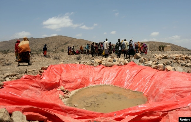 FILE - Displaced people gather at an artificial water pan near Habaas town of Awdal region, Somaliland, April 9, 2016. Across the Horn of Africa, millions have been hit by the severe El Nino-related drought.